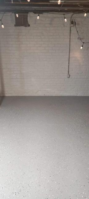 Omaha basement with sealed white brick wall and freshly coated gray floor