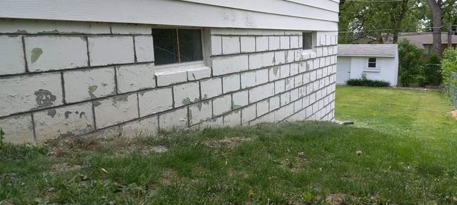Finished block foundation wall along a lawn after repair in Omaha