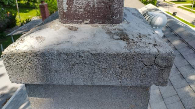 Cracked concrete chimney crown before repair on an Omaha roof