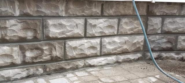 Rusticated rock-faced block foundation after full repointing in Omaha