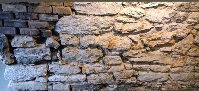 Historic limestone and brick foundation wall during repointing in Omaha
