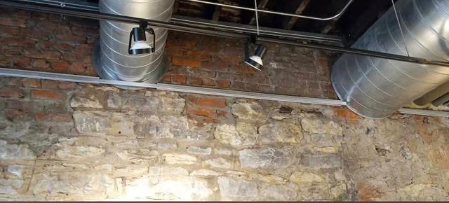 Restored exposed limestone wall inside a commercial building in Omaha