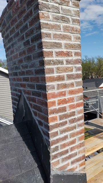 Corner of a repointed historic chimney in Omaha with new mortar joints and new flashing