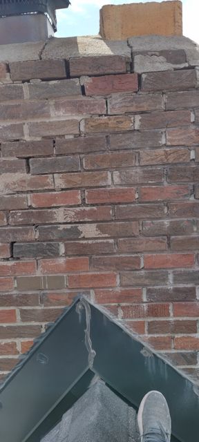 Close-up of a deteriorated chimney crown and open mortar joints before repair in Omaha